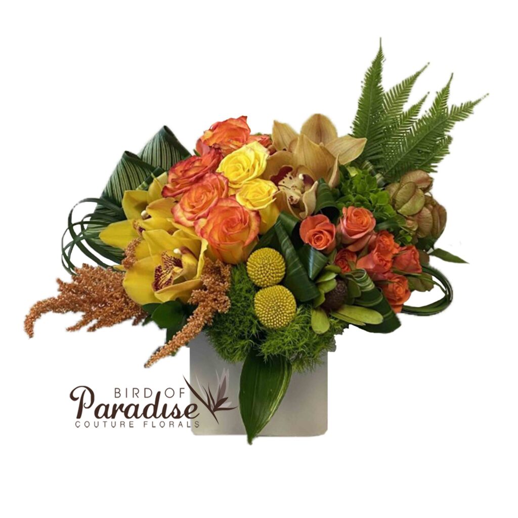 Fall colors join together to create this perfect seasonal arrangement! Includes roses, spray roses, cymbidium orchids, billy balls, hydrangeas, and greenery in a square white ceramic container.  Perfect for gifting to loved ones or adding to your holiday table.