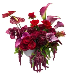 Beautiful and sweet, this red and purple flower arrangement makes the perfect Valentines Day gift! It includes roses, spray roses, anemones, calla lilies, cembedium orchids, peonies, antherium, and amaranthus arranged in a white ceramic vase