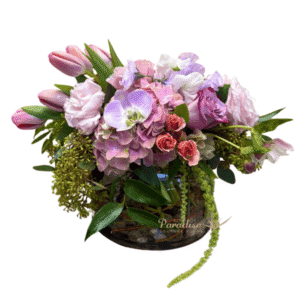 Fresh arromatic blooms make up this pink garden flower arrangement.  It includes hydrangeas, roses, spray roses, tulips, orchids, lisianthus, and greenery arranged in a cyllinder glass vase with pebbles and curly willow details.