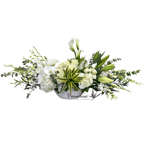 A gift from the your hearts to your loved ones. This sympathy arrangement with lilies includes hydrangeas, roses, orchids, calla lilies, and greenery arranged in a white ceramic container.  