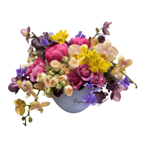 This colorful peony flower arrangement adds the perfect touch of magic into your home.  It includes hellaborus, rose, spray rose, sweet pea, and orchid arranged in a textured white ceramic container.