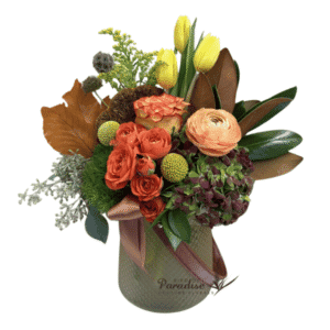 Welcome in the fall season with this fall theme flower arrangement.  It includes roses, spray roses, tulips, hydrangea, billy ball, salidago, greenery, and fall accents. All is arranged in a creamy yellow glass vase with decorative leather strap.